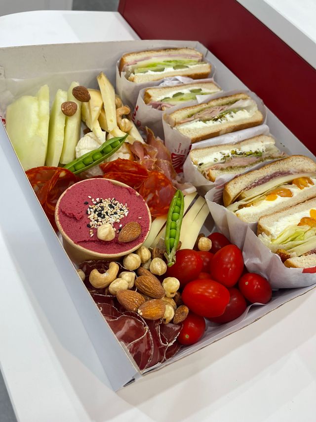 Sandwichs en boîte avec fruits, charcuterie, noix et fromage